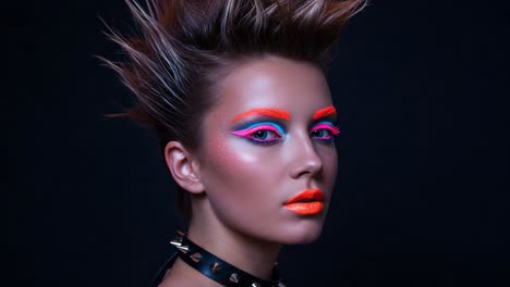 striking portrait of a model with bold neon makeup and edgy hairstyle, showcasing vibrant colors against a dark background in a fashion-forward style
