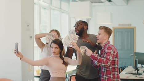 Jóvenes-Burlándose-Del-Dinero-En-El-Coworking.-Gente-Feliz-Tomándose-Selfie.