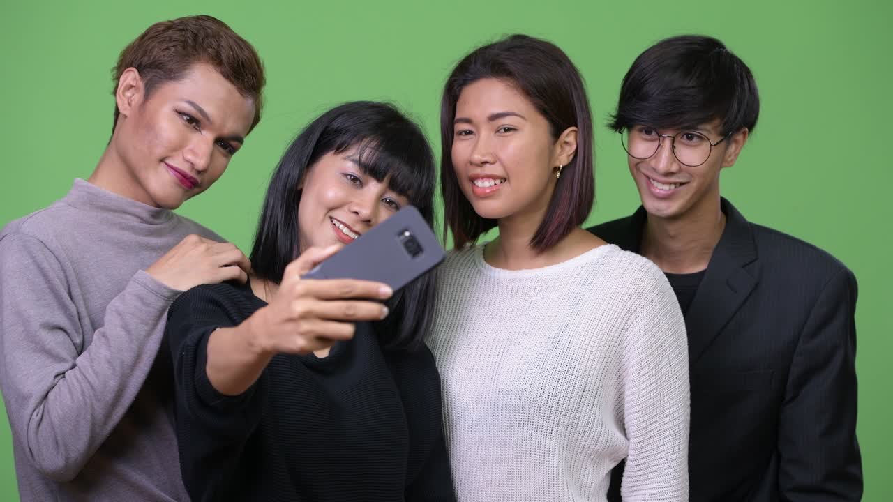 Group of happy Asian friends taking selfie together