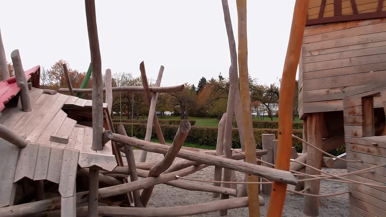 el dron vuela hacia adelante bajo y suavemente a través del patio de recreo, pasando muy cerca del equipo de juego