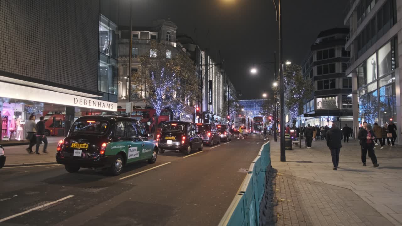 Black cab traffic on oxford street at night decorated for Christmas