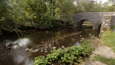 wide shot of stone bridge at wetton mill over the river