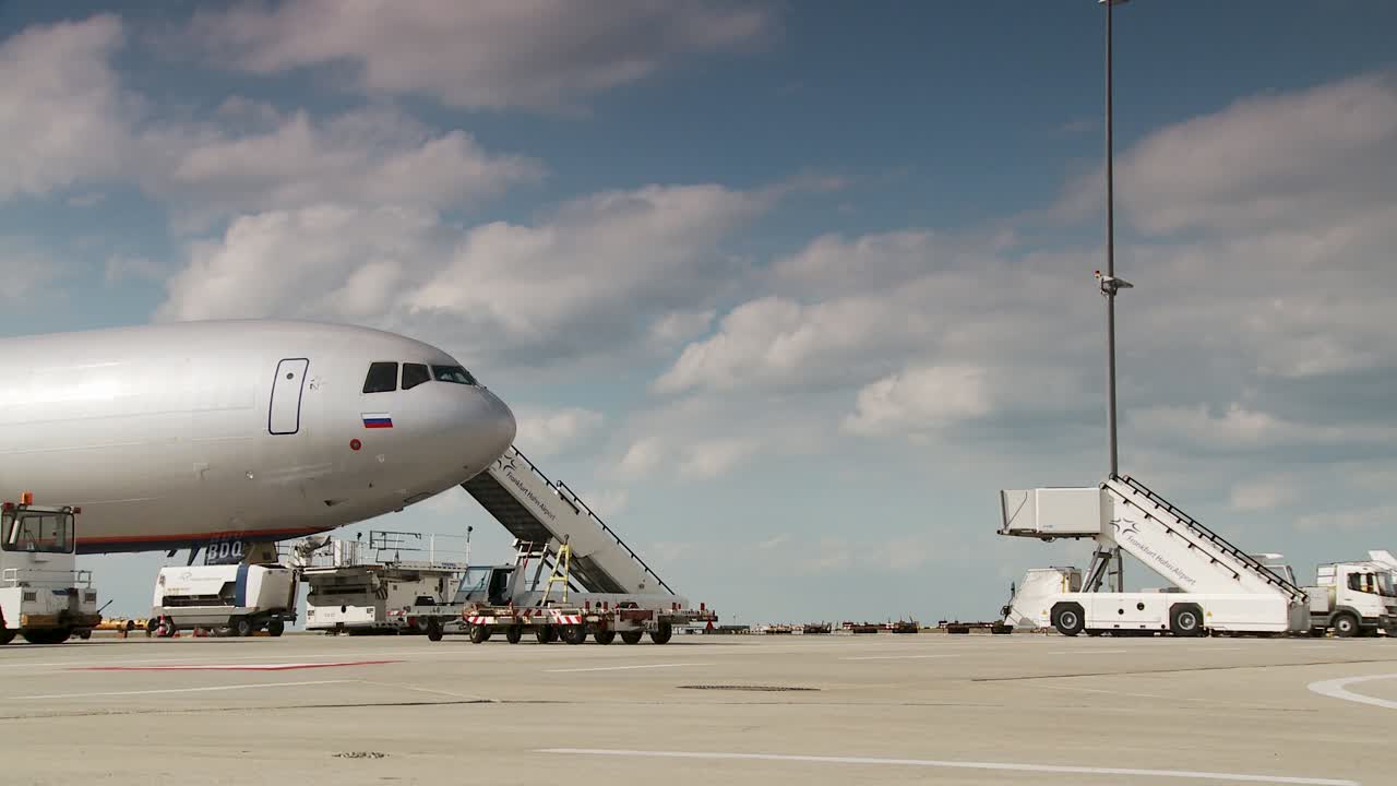 Parked airplane on runway with sky backdrop, serene travel vibe
