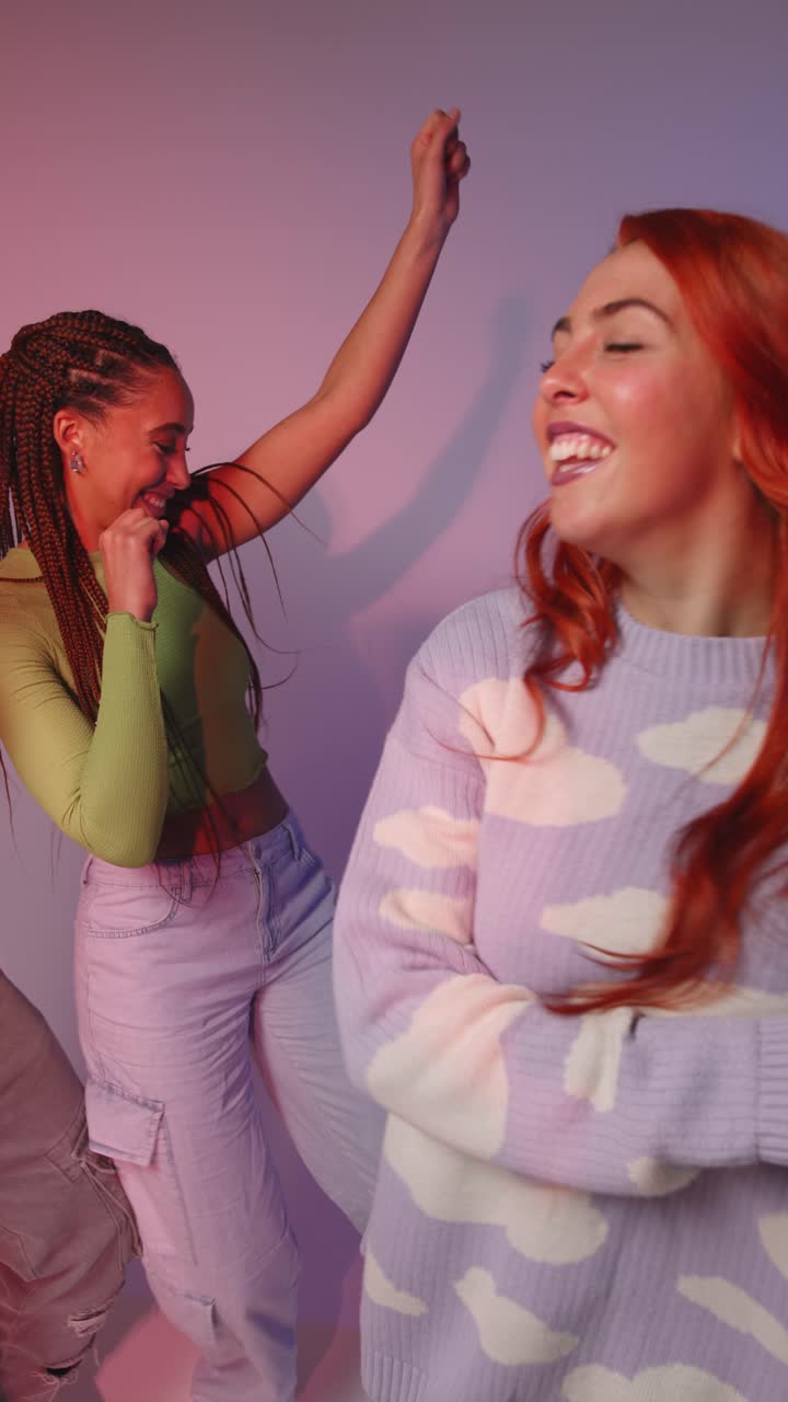 Vertical Video Studio Shot Of Vertical Video Of Group Of Gen Z Friends Dancing And Having Fun Against Pink Background 2