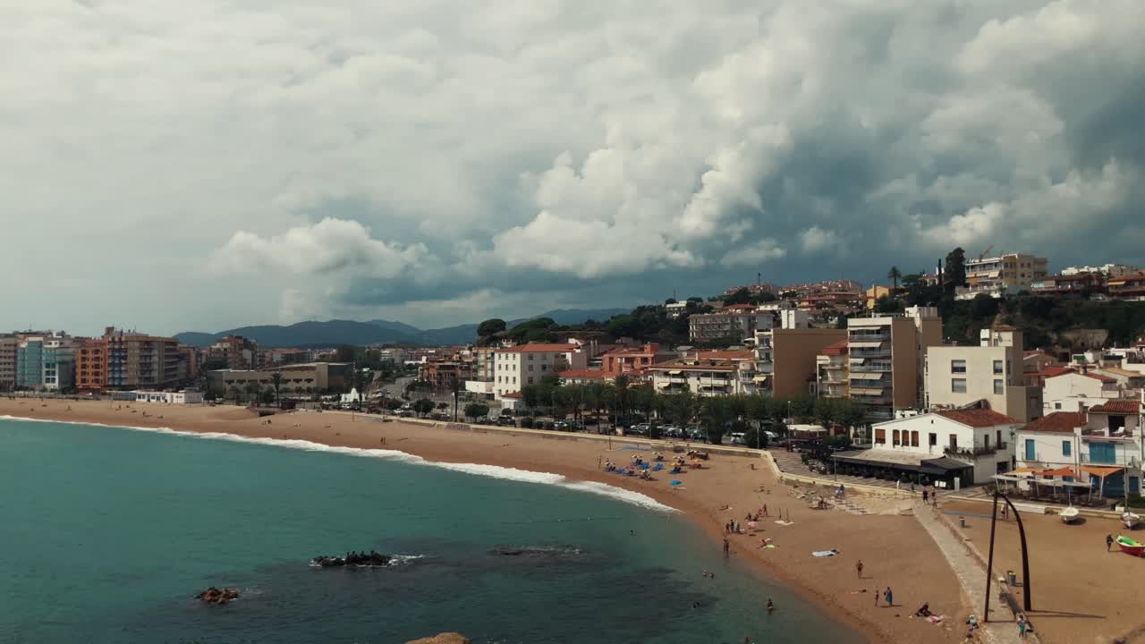 Cittadina costiera con spiaggia e cielo nuvoloso