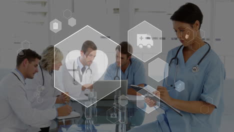 medical icons animating over healthcare professionals discussing and taking notes in hospital
