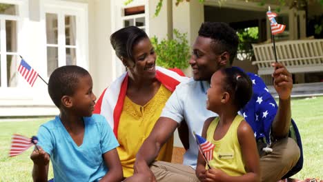 Familia-Sonriendo-Y-Sosteniendo-Pequeñas-Banderas-Americanas