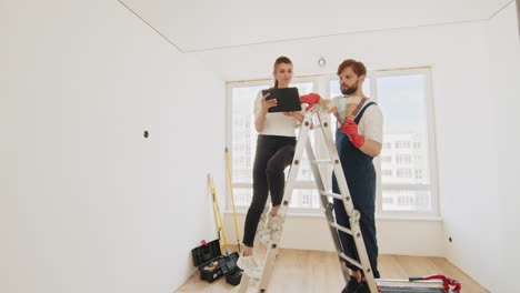 mujer y contratista eligiendo colores de pintura para una habitación