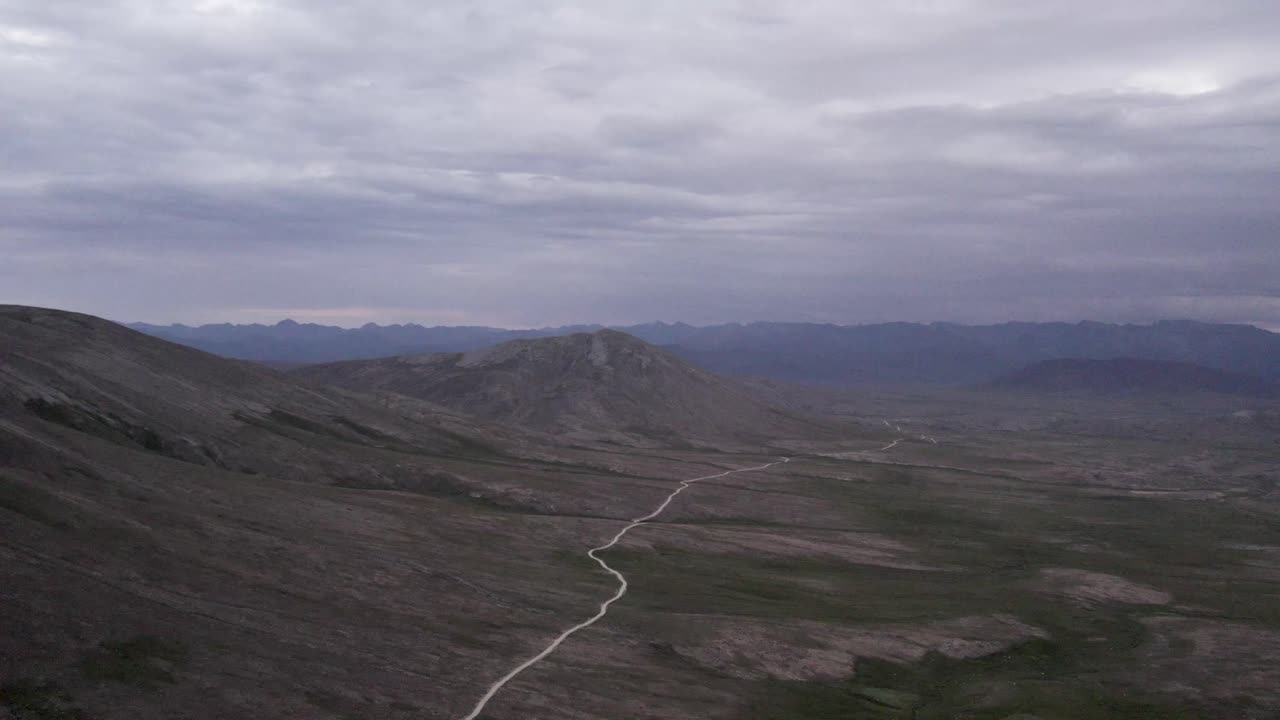 Wide-angle view of a winding road cutting through the vast plains of Deosai National Park