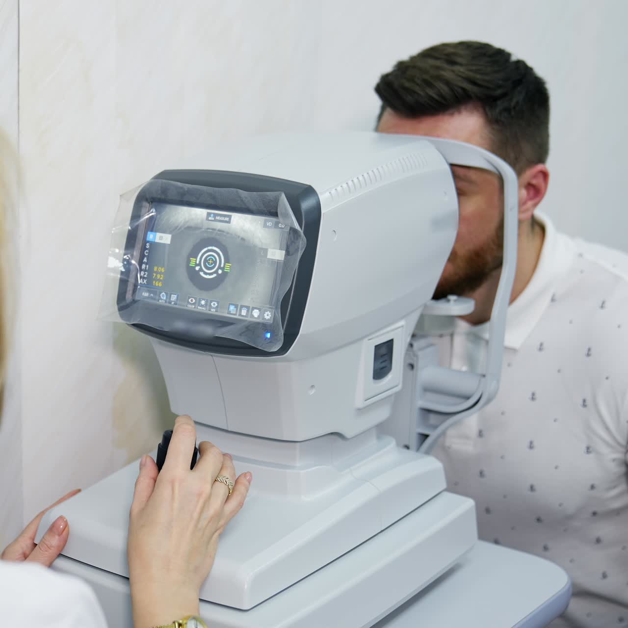 Oculist doctor works in a ophthalmology clinic. Woman specialist uses an apparatus for biomicroscopy of the eye to check the sight of an adult man