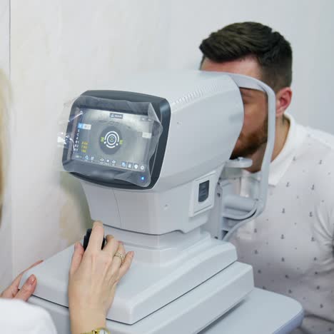 oculist doctor works in a ophthalmology clinic. woman specialist uses an apparatus for biomicroscopy of the eye to check the sight of an adult man