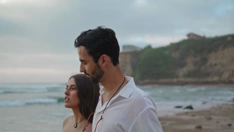 tender newlyweds enjoy ocean stormy beach closeup. people walking water shore