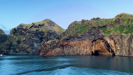 rock formations by coast of heimaey at vestmannaeyjar, iceland, pov from boat