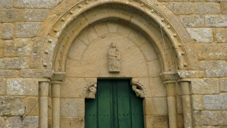 close-up of an ornate stone archway and green door of an ancient church