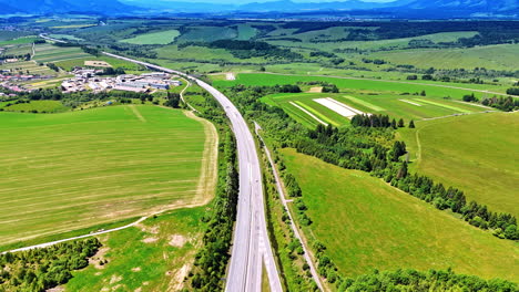 road passes the meadows in the countryside of slovakia. rural area at backdrop. aerial view