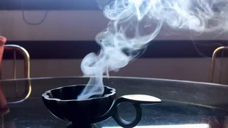 front view of charcoal resin brass burner with soothing smoke in slow motion