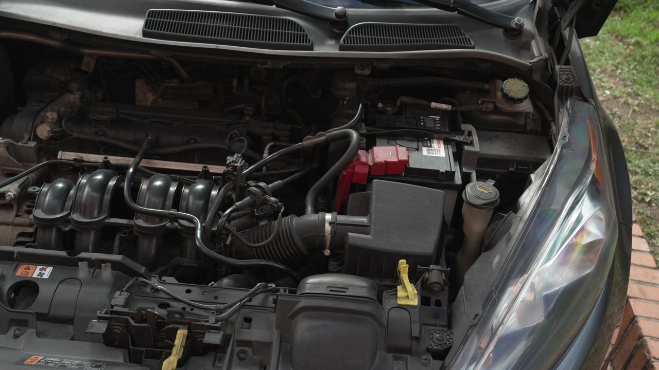 Close up view of a modern internal combustion car engine with the hood open, ready for maintenance