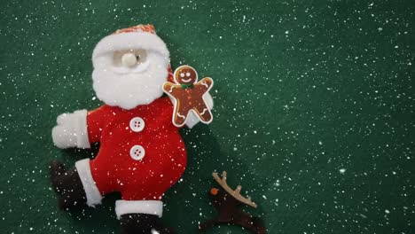 Video-composition-with-falling-snow-over-desk-with--santa-doll