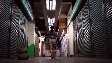 young ethnic woman walking in underground corridor