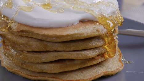 close-up of a delicious stack of pancakes as honey is drizzled on top