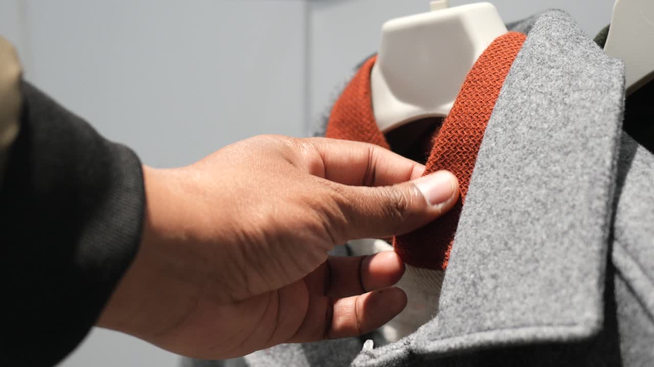Man Trying On a Gray Coat with an Orange Collar