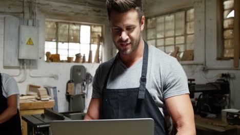 Zwei-Tischler-Schauen-Bei-Der-Arbeit-Auf-Den-Laptop