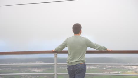 Rear-view-of-young-man-looking-at-landscape-at-Serra-do-Cume-viewpoint,-Azores