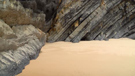 placas volcánicas tectónicas en la playa de gruta da adraga en portugal en un día soleado