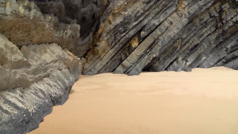 tectonic volcaninc plates in the beach of gruta da adraga in portugal on sunny day