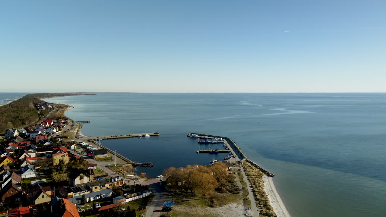 햇빛이 비치는 동안 다채로운 주택과 발트 해가 있는 쿠즈니카 항구 부두의 공중 전망 - 헬, 폴란드