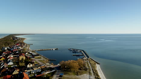 Aerial-view-of-Harbor-Pier-of-Kuznica-with-colorful-houses-and-Baltic-Sea-during-sunlight---Hel,Poland