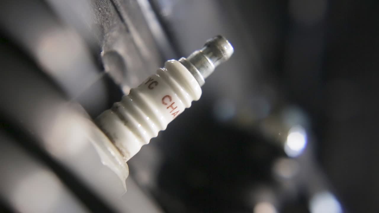 낮은 빛에서 기계 부품에 기름을 적용하는 손의 클로즈업