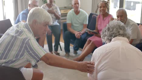 diverse seniors and female therapist with tablet talking in group therapy, unaltered, slow motion