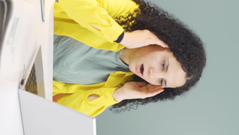 Vertical-video-of-Young-woman-looking-at-laptop-in-amazement.