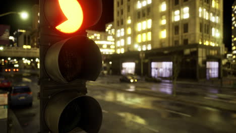 nighttime urban traffic light displaying a red signal in a bustling city