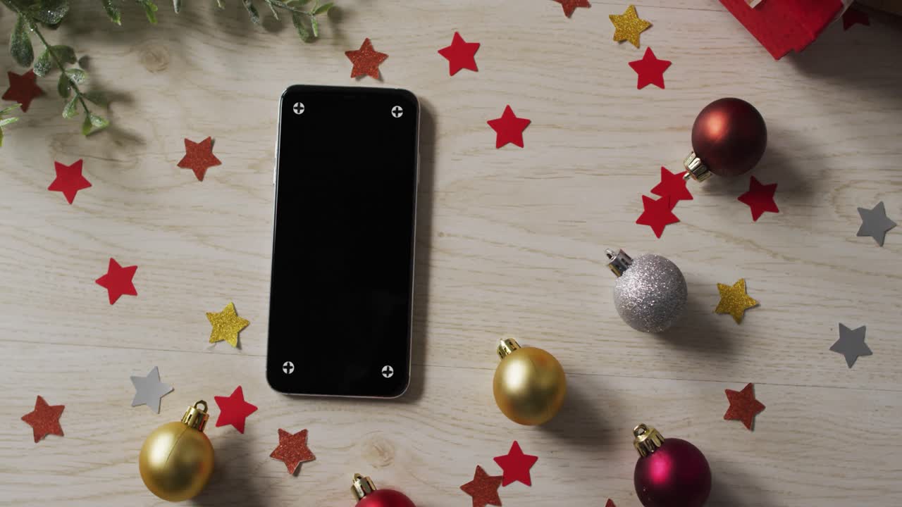 video de decoraciones de navidad bolas y estrellas con teléfono inteligente en una mesa de madera