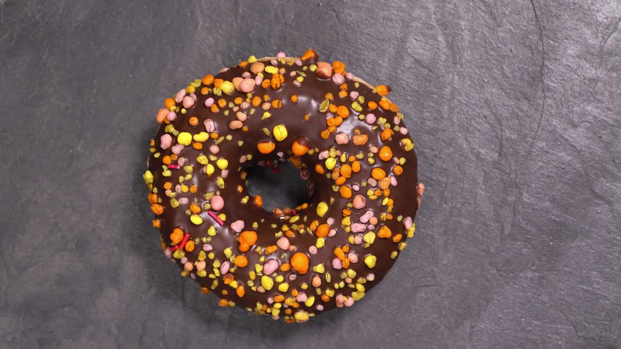 сладкий пончик вращается на темном фоне. традиционная американская сладость