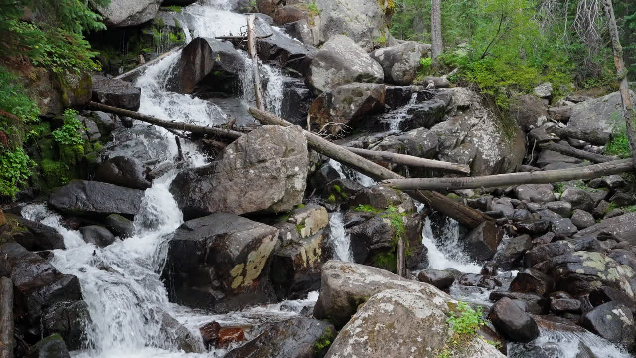 Air terjun megah di lanskap hutan yang mengalir di atas bebatuan di alam yang tenang