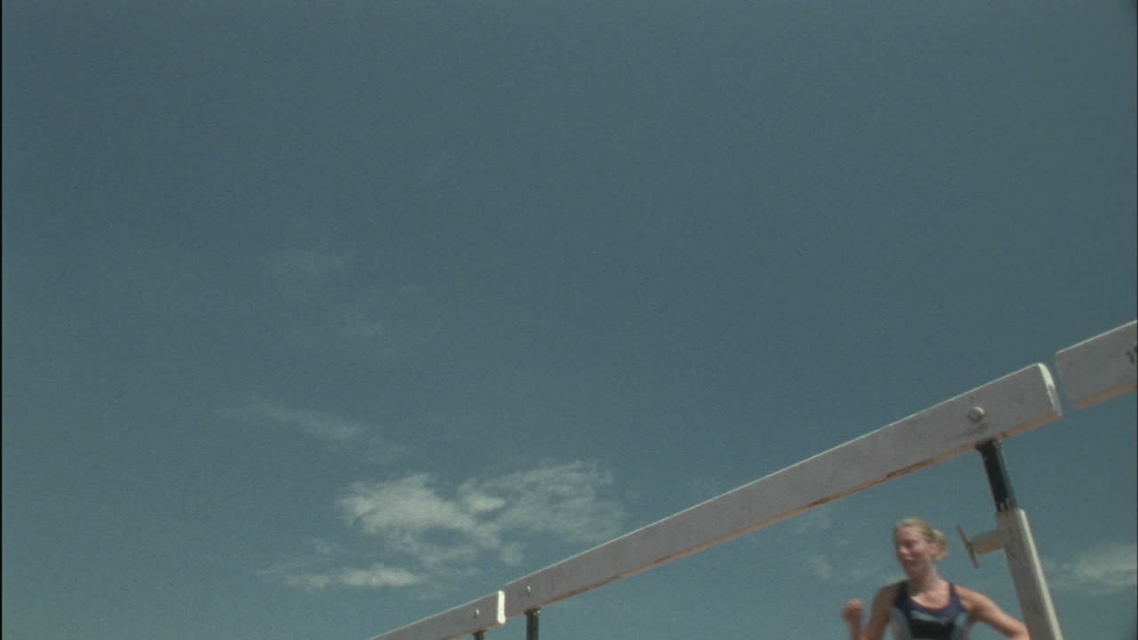 여성 주자가 장애물을 뛰어 넘다