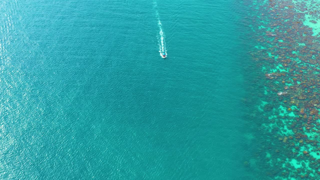 vista aérea de botes de cola larga flotando en aguas cristalinas a lo largo de la playa de arena en tailandia