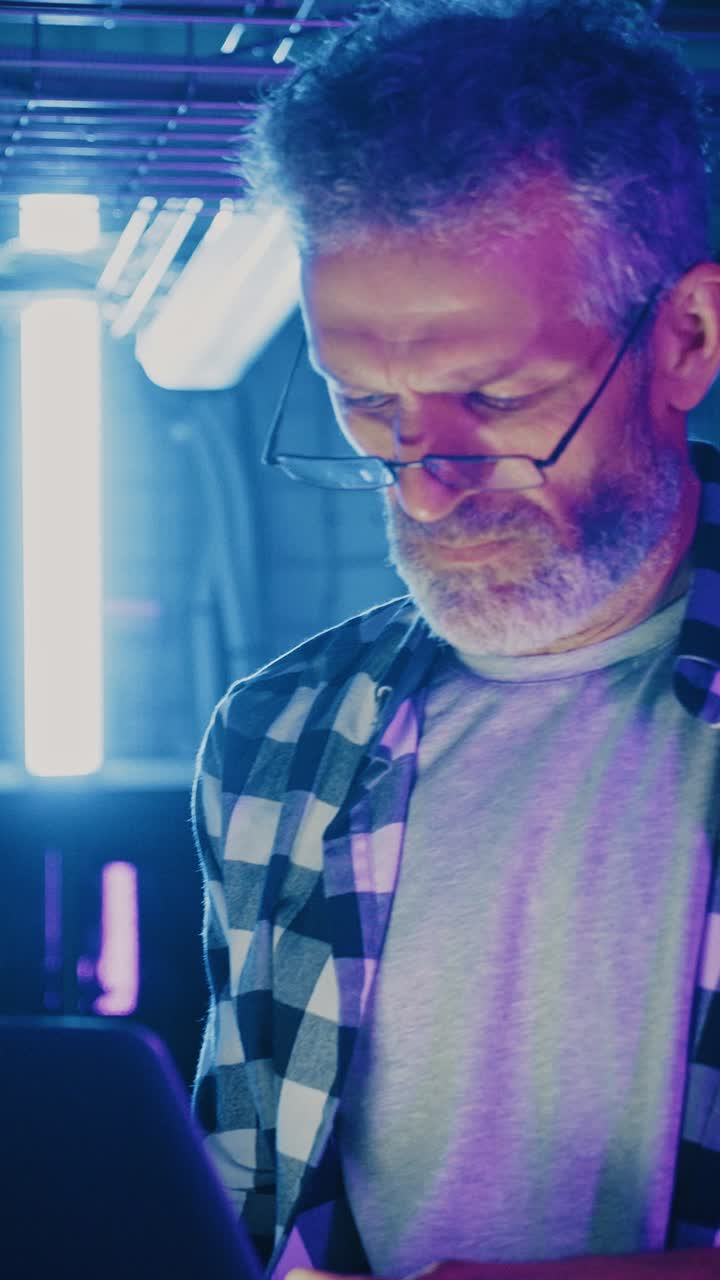 Man working on a laptop in a dimly lit room