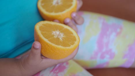 niño sosteniendo naranjas en rodajas