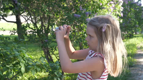 young caucasian blonde girl taking pictures of nature with camera