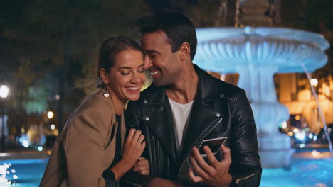 happy spouses holding photo in night park closeup. joyful couple kissing on date