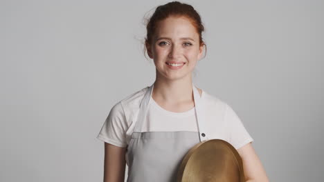 redheaded waitress in front of camera on gray background.