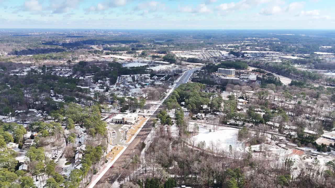 Paesaggio suburbano innevato con alberi e case sotto un cielo blu, Cary, Carolina del Nord, USA.