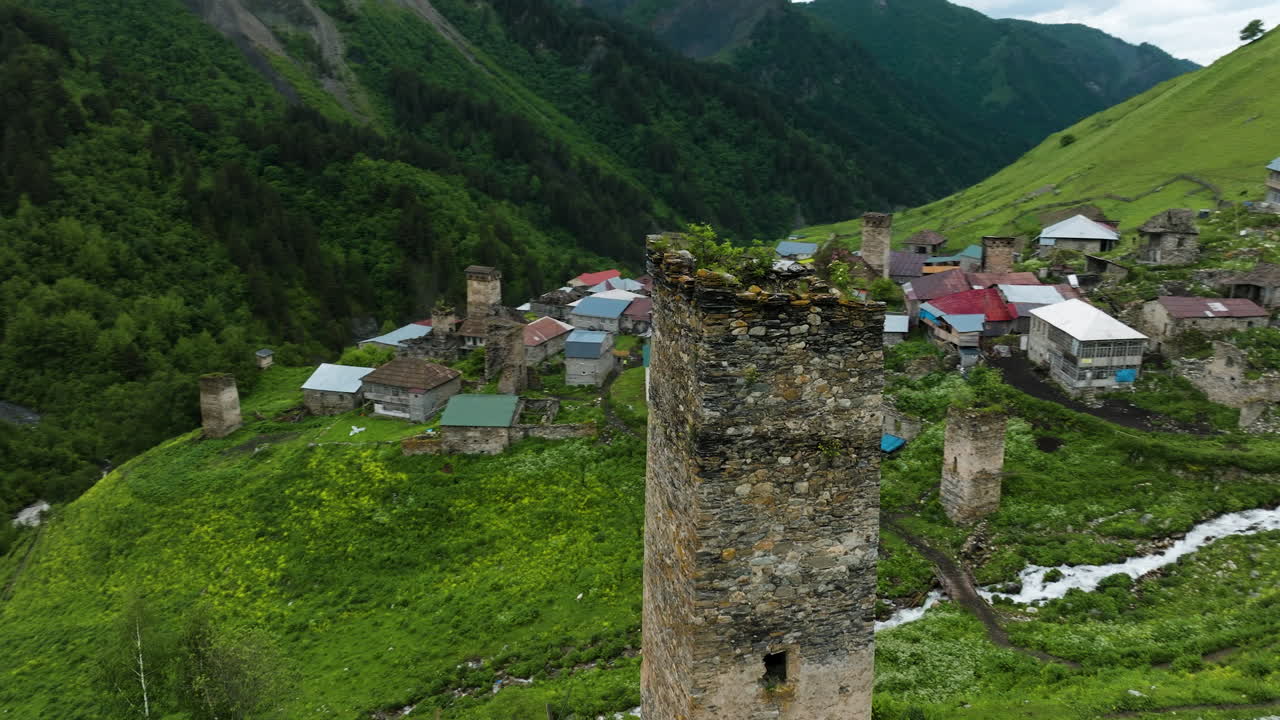 Vista aérea de ruínas de uma torre antiga na Vila Adishi, com as Montanhas do Cáucaso da Região de Svaneti na Geórgia.