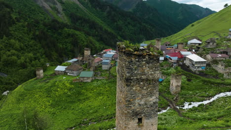 aerial view of old tower ruin on adishi village with caucasus mountains of svaneti region in georgia