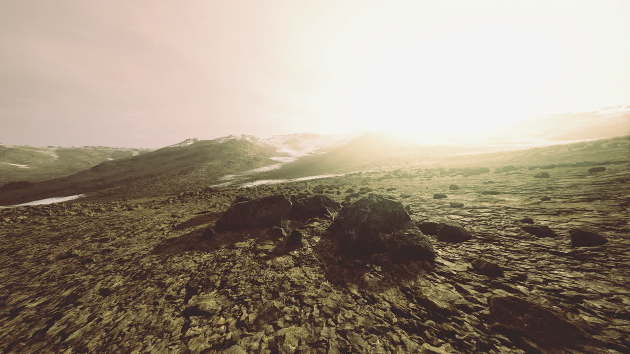 Vast mountainous landscape bathed in golden sunlight at dawn