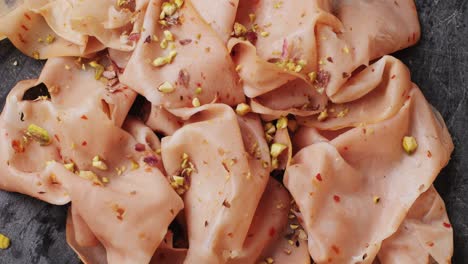 ham italian mordatella, man slices of traditional italian antipasti mortadella sausage on a wooden cutting board, close up macro of chicken or turkey jamon, fat breakfast dish.